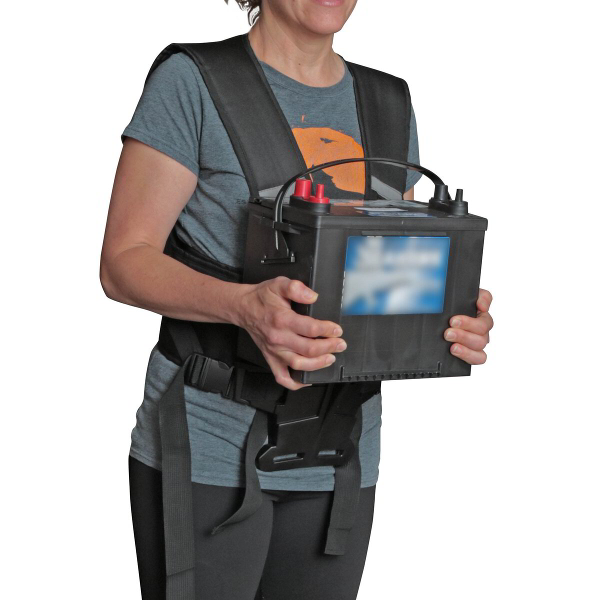 Worker carrying a heavy battery pack supported on The Body Shelf harness shelf at waist height