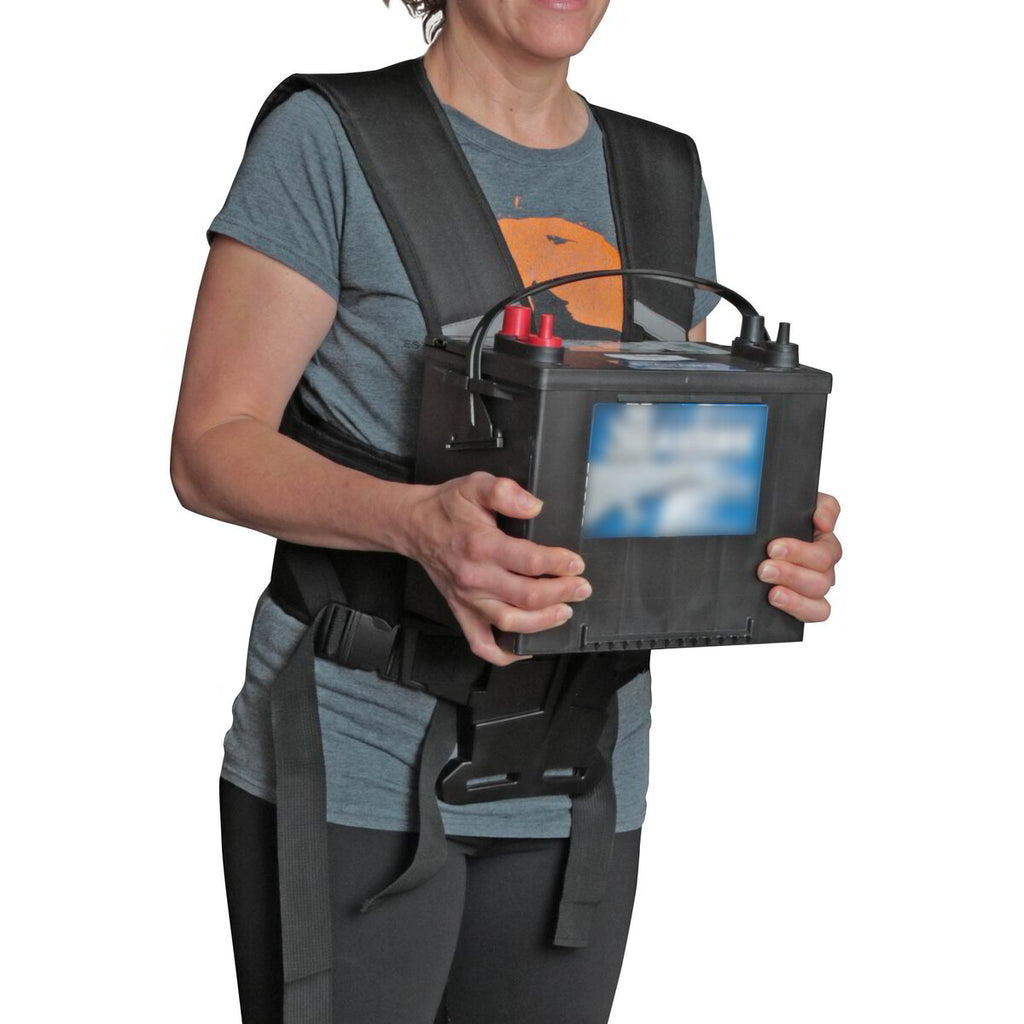 Worker carrying a heavy battery pack supported on The Body Shelf harness shelf at waist height